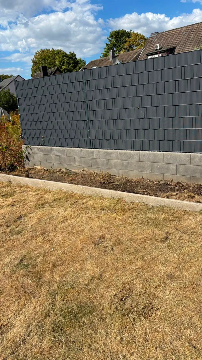 Bepflanztes Gartenbeet an einer Grundstücksgrenze